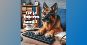 Hund sitzt am Schreibtisch vor dem PC.